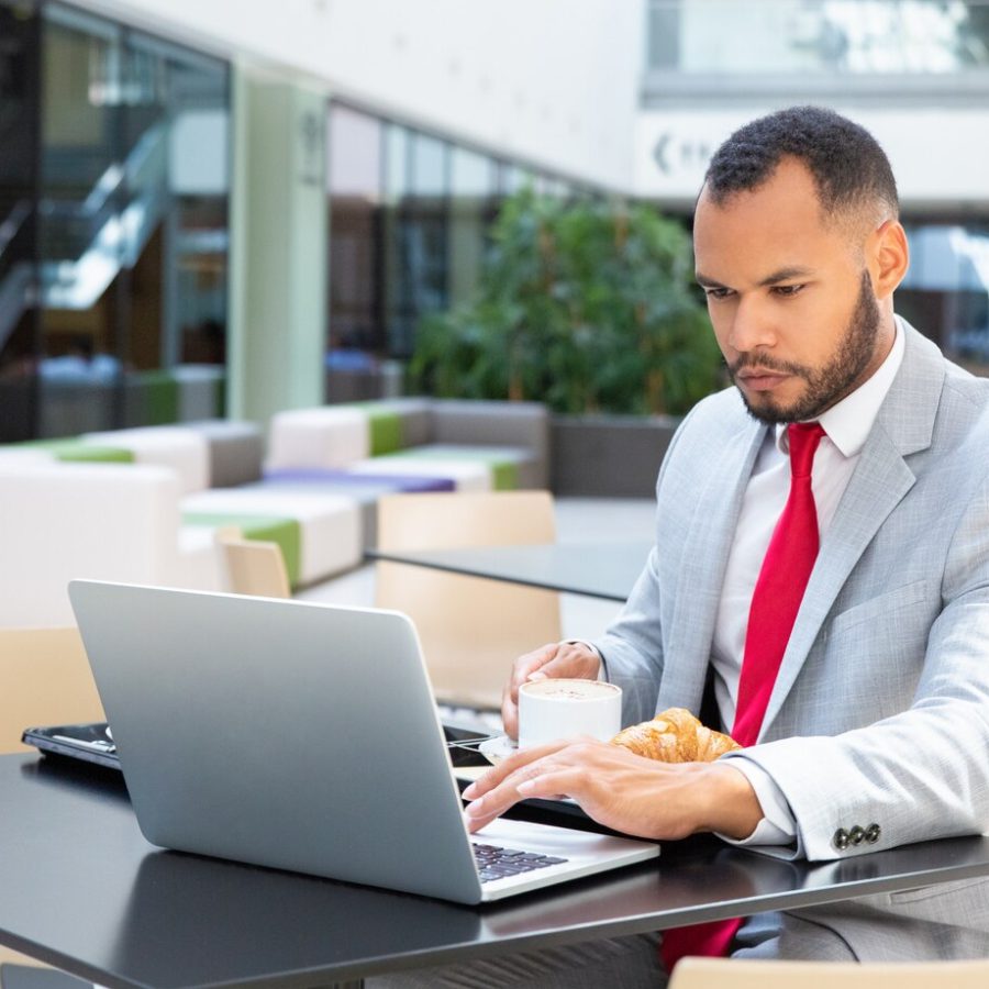 serious-businessman-using-laptop-cafe_74855-1221